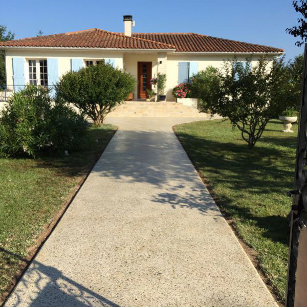 Allée piétonne en béton poncé, cailloux ocre - Jonzac